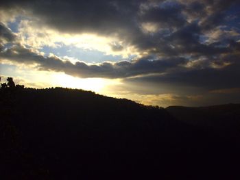 Scenic view of silhouette mountains against dramatic sky