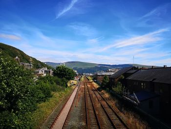 Railroad tracks amidst buildings against sky