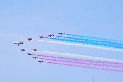 Low angle view of kites flying against clear sky