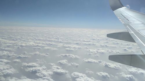 Airplane wing flying over clouds