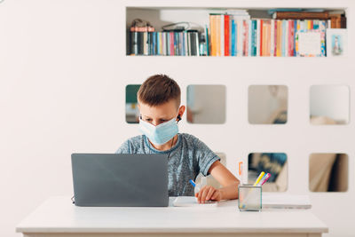 Man using mobile phone while sitting on table