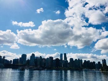 River amidst buildings in city against sky