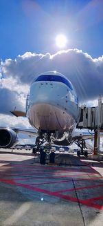 Airplane on airport runway against sky