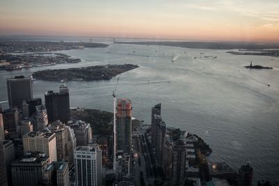 Aerial view of city and hudson river against sky during sunset