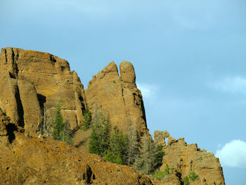 Low angle view of rock formations against sky