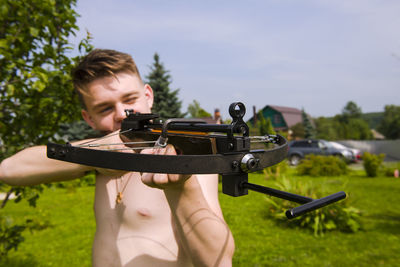 Close-up of man holding crossbow