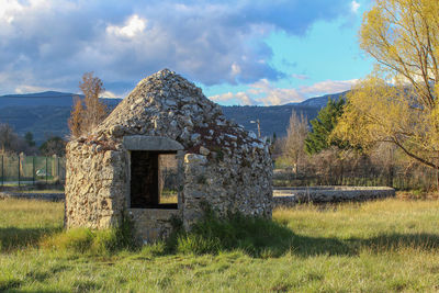 Built structure on field against sky