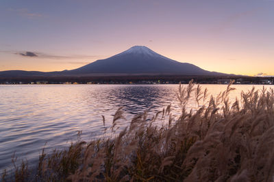 Scenic view of lake and mountains against sky during sunset