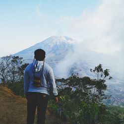 Man standing on mountain against sky