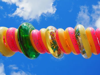 Low angle view of multi colored balloons against sky