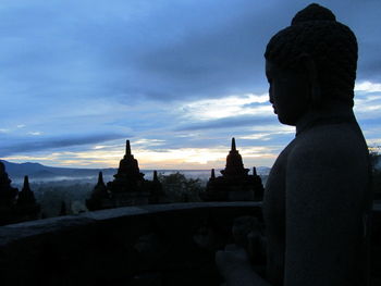 Silhouette of statue against cloudy sky