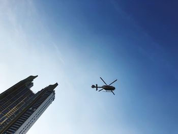 Low angle view of airplane flying in building against sky