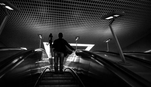Low angle view of man with tripod on escalator at maryina roshcha metro station