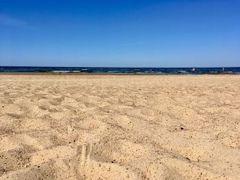 Scenic view of beach against clear blue sky