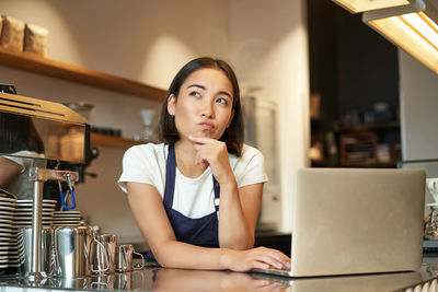 Young woman using laptop at table