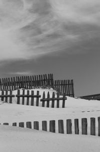 Wooden fence on snowcapped landscape