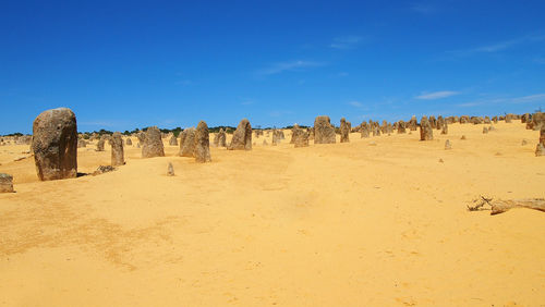 Panoramic view of desert against blue sky