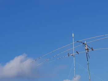 Low angle view of cables against clear blue sky