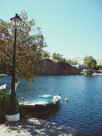 Boats moored in lake against clear sky