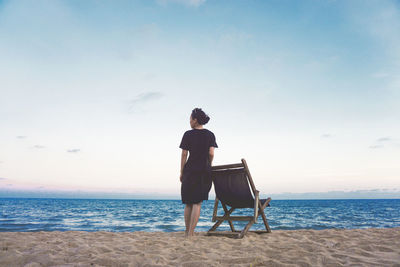 Rear view of man looking at sea against sky