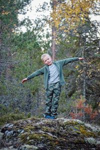 Full length of boy standing in forest