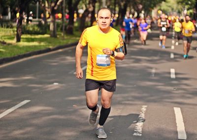 Portrait of man running on road during marathon