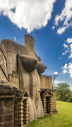 Low angle view of sculpture on field against sky