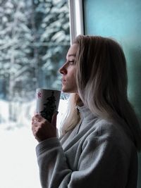 Portrait of a young woman using mobile phone in winter