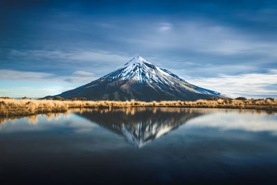 Scenic view of snowcapped mountains reflecting on lake against sky