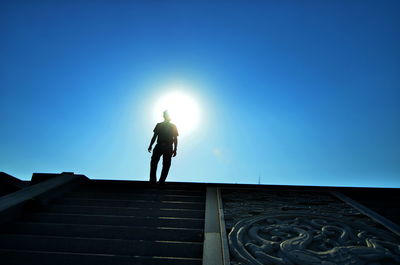 Low angle view of man on steps against sky