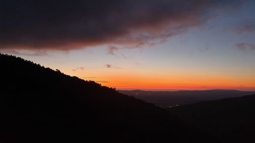 Scenic view of silhouette mountains against sky during sunset