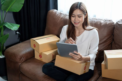 Portrait of smiling young woman holding gift box