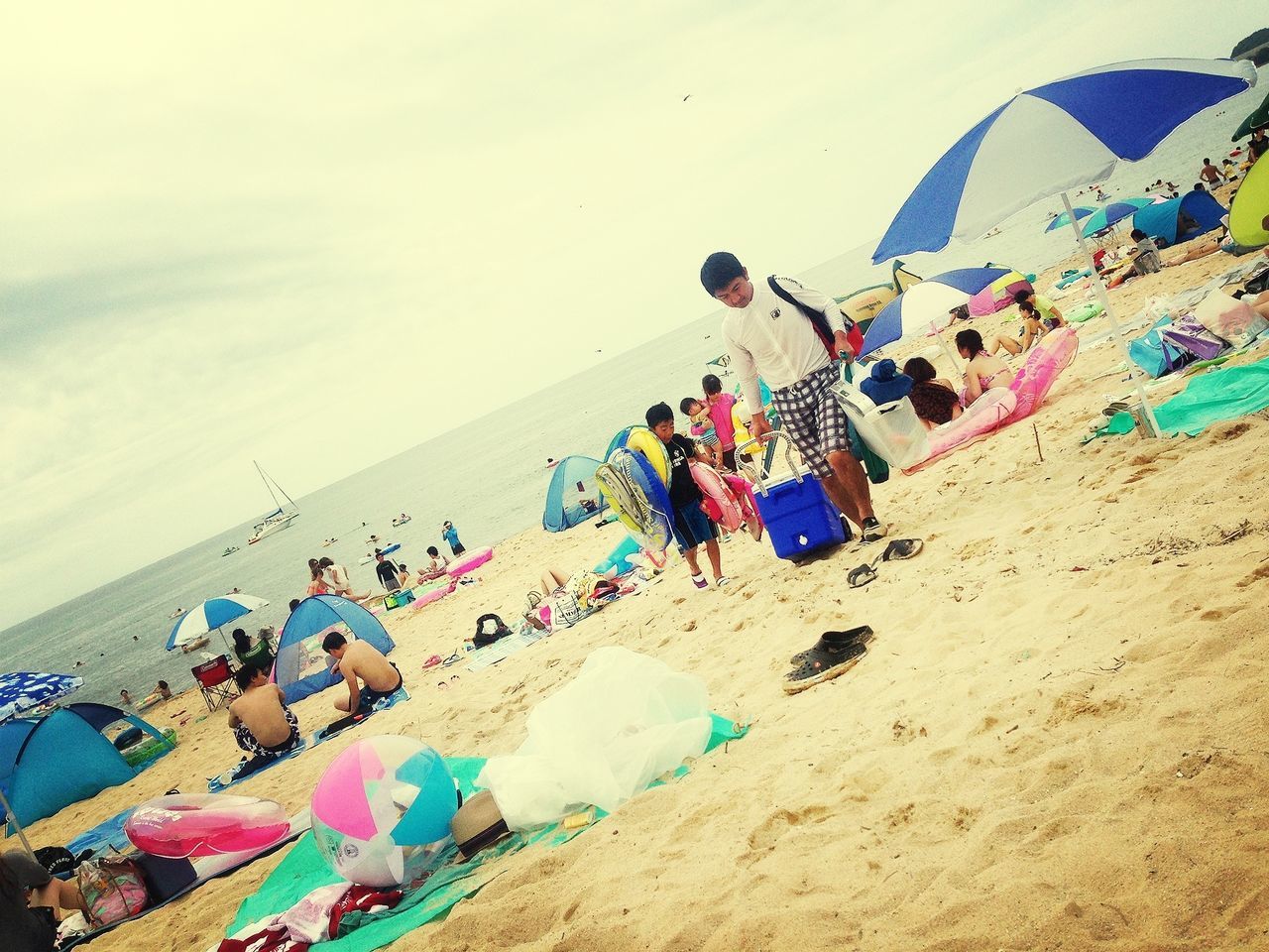 beach, large group of people, multi colored, sand, leisure activity, sea, vacations, enjoyment, lifestyles, shore, fun, men, person, beach umbrella, day, high angle view, blue, outdoors, summer