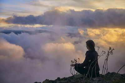 Rear view of man sitting against sky