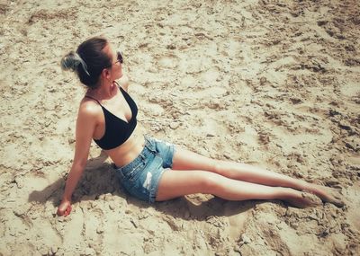 High angle view of young woman lying on sand