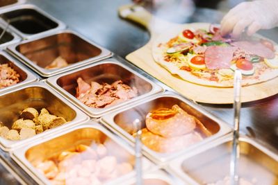 Cropped hand of person by pizza at store