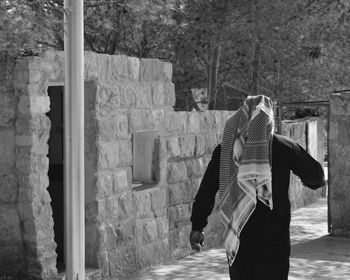 Rear view of woman standing in front of building