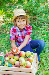 Portrait of cute girl eating apples in yard