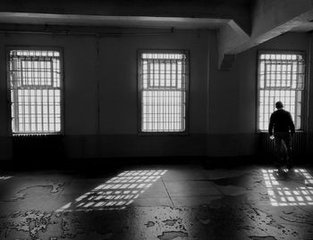 Rear view of silhouette man walking in building