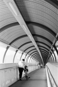 Rear view of man walking on escalator