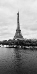 Eiffel tower in city against cloudy sky