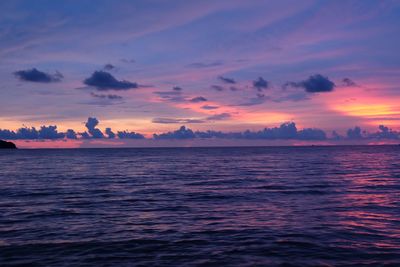 Scenic view of sea against dramatic sky during sunset