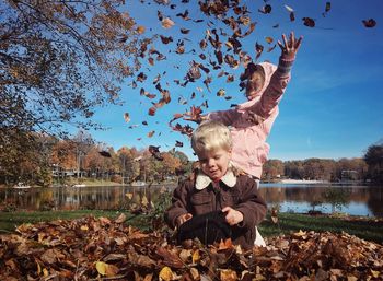 Children playing with autumn leaves at park