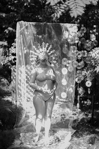 Rear view of woman in mask standing in garden 