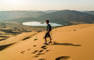 Man standing on sand dune at badain jaran desert