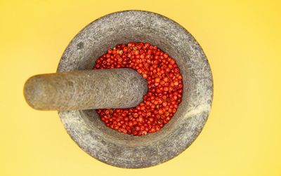 Directly above shot of strawberries in container against yellow background