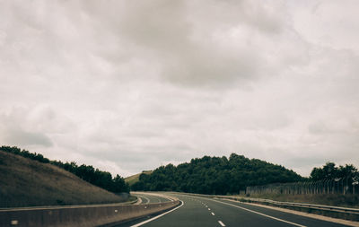 Road passing through landscape against sky