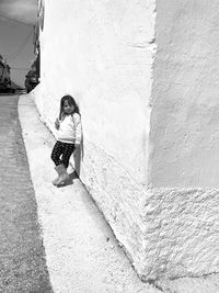 Rear view of woman standing against wall