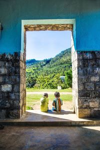 Children sitting on window of building