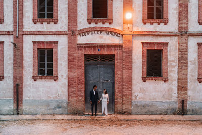 Rear view of people standing outside building